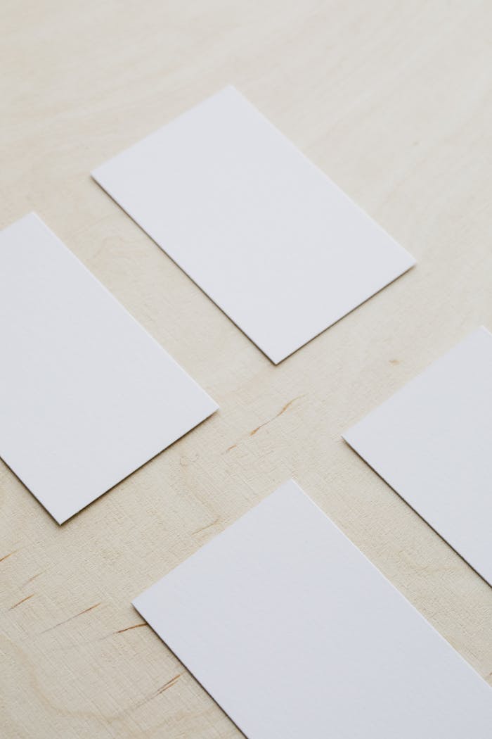 The Art of Drawing Readers In: Your attractive post title goes here From above of white mockup rectangular visiting cards arranged neatly on wooden table
